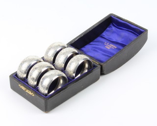 A cased set of 6 Victorian silver napkin rings with chased decoration Birmingham 1898, maker Rolason Bros 84 grams 