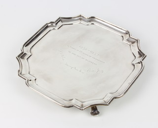 A silver salver with Chippendale rim and presentation inscription on scroll feet, London 1913, maker Goldsmiths and Silversmiths 672 grams 25.5cm 