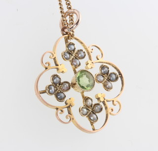 An Edwardian yellow gold, peridot and seed pearl pendant on a do. chain 