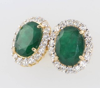 A pair of yellow gold oval emerald and diamond cluster ear studs, the emeralds approx. 6ct, the diamonds approx. 2ct 11mm x 9mm 