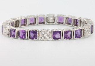 An 18ct white gold amethyst and diamond bracelet set with 18 square cut amethysts approx. 16ct interspersed with 30 brilliant cut diamonds approx. 0.6ct, 17.5cm, with certificate 