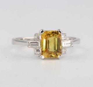 An 18ct white gold yellow sapphire and diamond ring, the yellow sapphire approx. 1.6ct flanked by baguette and princess cut diamonds approx. 0.21ct size N 