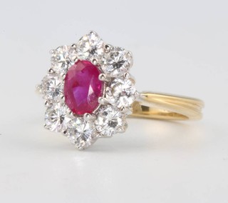 An 18ct white gold oval ruby and diamond cluster ring the centre stone approx 0.96ct surrounded by brilliant cut diamonds approx. 1.5ct size M 1/2