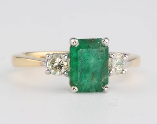 An 18ct yellow gold emerald and diamond ring, the centre stone approx. 1.4ct flanked by brilliant cut diamonds approx 0.28ct, size M 