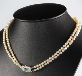 A double strand cultured pearl necklace with a platinum and 18ct emerald and diamond clasp 41cm 