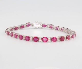 An 18ct white gold ruby and diamond line bracelet, the rubies approx. 13.17ct the diamonds approx. 0.67ct 