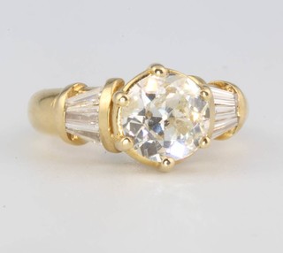 A yellow gold brilliant cut diamond ring, the centre stone approx. 1.85ct flanked by tapered baguette cut diamonds size K 