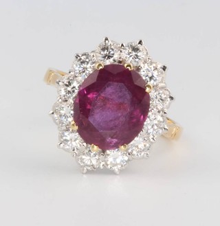 A yellow gold oval ruby and diamond cluster ring, the stone approx. 4ct surrounded by 12 brilliant cut diamonds size M 