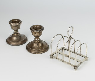 A silver 5 bar domed toast rack on ball feet Sheffield 1911 8cm, a pair of dwarf candlesticks 7cm 