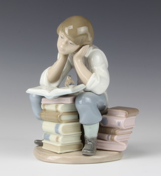 A Lladro group of a student sitting a stack of books with a bird nesting on a page 15cm 