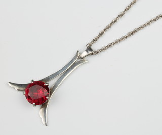 A stylish silver necklace set with a brilliant cut garnet on a do. chain 