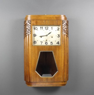 A French Art Deco 8 day striking wall clock with rectangular silvered dial, silvered Arabic  numerals contained in a carved walnut case, the dial marked Carillon De France Angelus