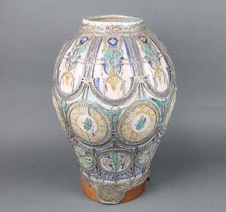 An Iznik style baluster vase decorated with panels of scrolls and flowers with  white metal filigree wire work 57cm h 