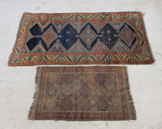 A Kurdish rug, the indigo field with 3 cross medallions 229cm x 119cm (in wear), together with 1 other Kurdish rug the field filled with polychrome mir ie boteh  (in wear) 136cm x 84cm 