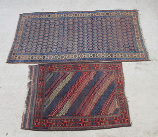 An antique Baluch rug with interlinking diagonal bands of polychrome decoration 148cm x 107cm (13cm hole to the centre, reduced in size and in wear) together with 1 other Baluch rug with blue and red ground 234cm x 125cm (in wear) 