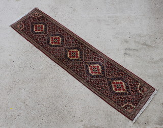 A pink ground and floral patterned Persian runner with floral ground and 5 diamonds to the centre 238cm x 58cm 
