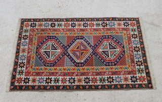 A Turkish Caucasian style rug with 3 diamonds to the centre within a multi-row border 180cm x 112cm 