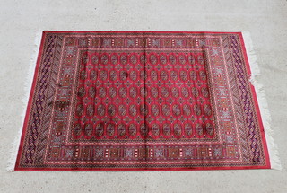 A red ground Bokhara style Belgian cotton rug with multi row borders 190cm x 140cm 