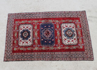A Caucasian rug with 3 rectangular medallions to the centre within a multi row border 160cm x 107cm 