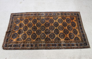 A rust ground Afghan rug with numerous octagons to the centre 271cm x 148cm 