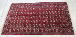 A red and white ground Tekke Turkoman carpet with 53 octagons to the centre within a multi row border 346cm x 201cm 
