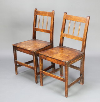 A pair of 18th Century elm stick and rail back hall chairs with solid seats, raised on square tapering supports, both frames are loose 