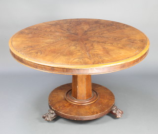A Victorian circular quarter veneered snap top breakfast table, raised on a chamfered column and circular base with paw feet 73cm h x 118cm diam.  