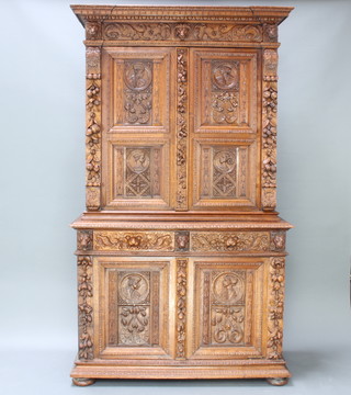 A Victorian carved oak cabinet on cabinet, the upper section with moulded cornice having a cupboard enclosed panelled doors, the base fitted 2 short drawers above a double cupboard enclosed by panelled doors, carved lions throughout and raised on bun feet  229cm h x 133cm w x 54cm d 