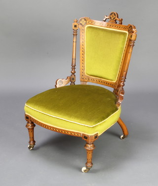 A Victorian inlaid mahogany nursing chair, the seat and back upholstered in green material (frame loose) 