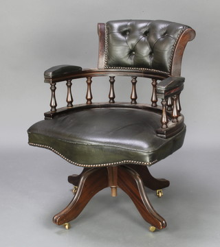 A mahogany revolving office chair upholstered in green buttoned back leather 