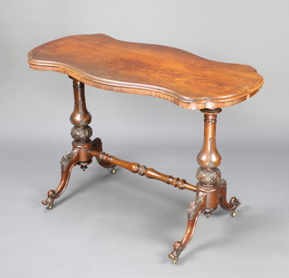 A Victorian rosewood stretcher table of serpentine outline with turned and carved H framed stretcher, raised on scroll supports 74cm h x 108cm w x 53cm d 