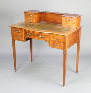 An Edwardian inlaid mahogany bow front writing table, the raised back fitted 2 drawers and with inset leather writing surface above 1 long and 2 short drawers, raised on square tapered supports  89cm h x 92cm w x 51cm d 