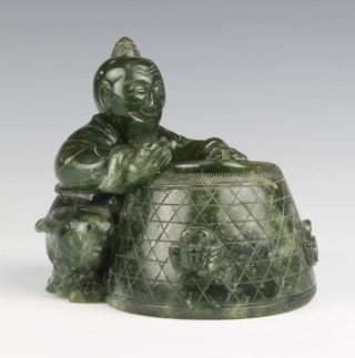 A Chinese jade brush washer in the form of a fisherman seated before a basket decorated with a crab holding a fish in his hand, 10.5cm 