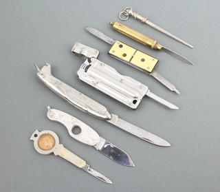 Six novelty knives, a silver cigar cutter, a lighter knife, domino knife and a miniature steel 