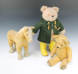 A Paddington Bear 50cm with yellow wellingtons (no hat), a yellow teddy bear  with articulated limbs 48cm and a yellow figure of a standing horse 36cm 