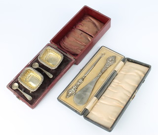 A cased Edwardian silver button hook and shoe horn Chester 1905 and a cased pair of salts 