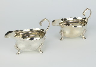 A pair of silver sauce boats with S scroll handles, shell knees and pad feet London 1937, 184 grams