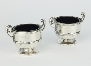 A pair of Edwardian silver table salts in the form of 2 handled trophies with blue glass liners Birmingham 1905, 2 silver knife rests, 146 grams
