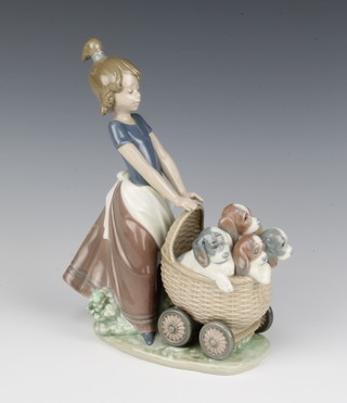 A Lladro figure of a girl pushing a pram containing puppies 5364, 23cm 