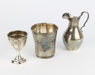 An Edwardian silver baluster cream jug Chester 1905, an engine turned beaker and an egg cup 128 grams 
