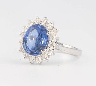An 18ct white gold oval sapphire and diamond cluster ring, the centre stone 4.42ct surrounded by brilliant cut diamonds 0.69ct, size M 