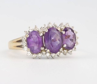 A 9ct yellow gold amethyst and diamond triple cluster ring size T 1/2