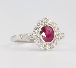 An 18ct white gold oval ruby and diamond cluster ring, size P 
