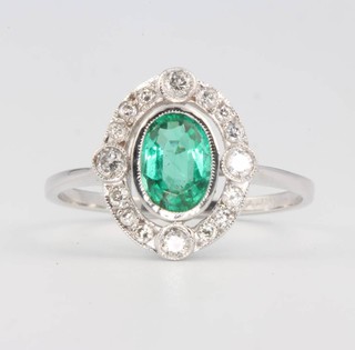 An 18ct white gold oval emerald and diamond ring size N 1/2
