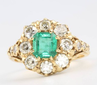 An 18ct white gold emerald and diamond cluster ring, the centre stone approx. 1.20ct surrounded by brilliant cut diamonds approx. 1.3ct, size N 1/2