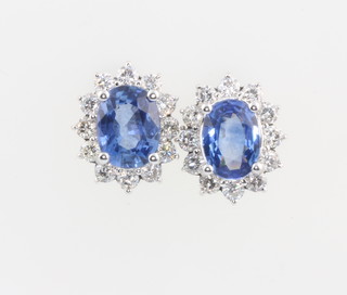 A pair of 18ct white gold sapphire and diamond oval cluster ear studs, the sapphires 4.41ct, the brilliant cut diamonds 1.16ct 14mm x 12mm 