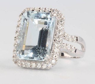 An 18ct white gold rectangular cut aquamarine and diamond ring, the centre stone approx. 7cts, the brilliant cut diamonds 0.51ct, size L 1/2