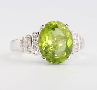 A 14ct white gold oval cut peridot and diamond ring, the centre stone approx. 3.56ct, the brilliant cut diamonds approx. 0.25ct size L 1/2