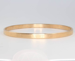 A 9ct yellow gold bangle with chased decoration 29 grams