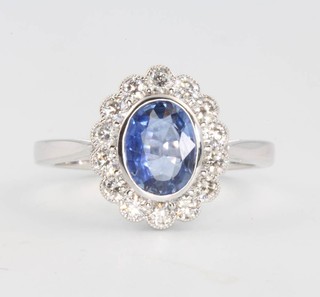 An 18ct yellow gold oval sapphire and diamond ring, the centre stone approx. 1.36ct surrounded by brilliant cut diamonds 0.61ct, size O 1/2, 13mm x 11mm 